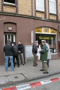 Polizeibeamte stehen in Kassel vor einem Internetcafe, in dem der angeschossene 21-jährige Halit Y. gefunden wurde