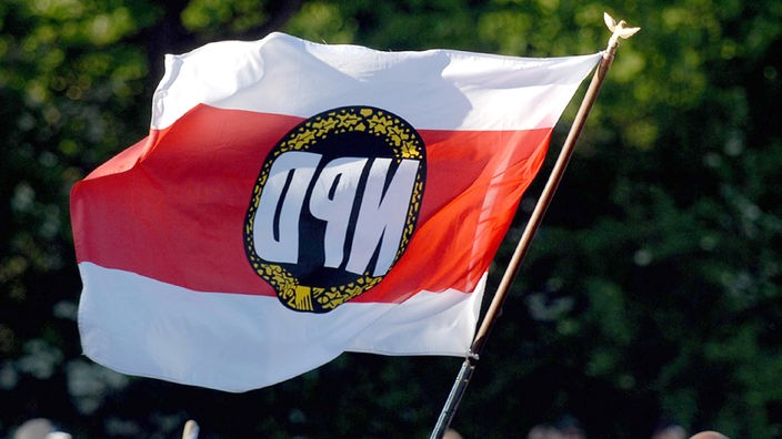Eine Fahne mit der NPD wird in Dortmund bei einer Demonstration verschiedener rechter Gruppierungen geschwenkt