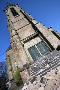 Steine, die sich von einem Kirchturm gelöst haben, liegen auf der Treppe vor dem Kircheneingang 