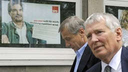 Der frühere Bundeswirtschaftsminister Wolfgang Clement (li.) und Otto Schily gehen an einem Werbeplakat der SPD vorbei