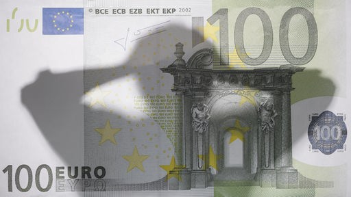 Silhouette eines Mannes auf 100-Euro-Geldschein
