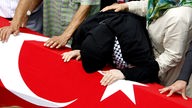 Trauernde Frau auf türkischer Flagge