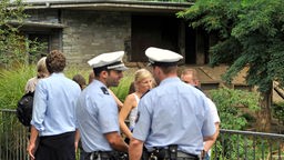 Polizisten und Besucher stehen vor dem Tigergehege im Zoo Köln