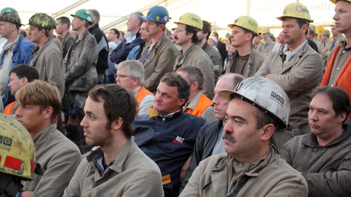 Bergarbeiter verfolgen eine öffentliche Betriebsversammlung