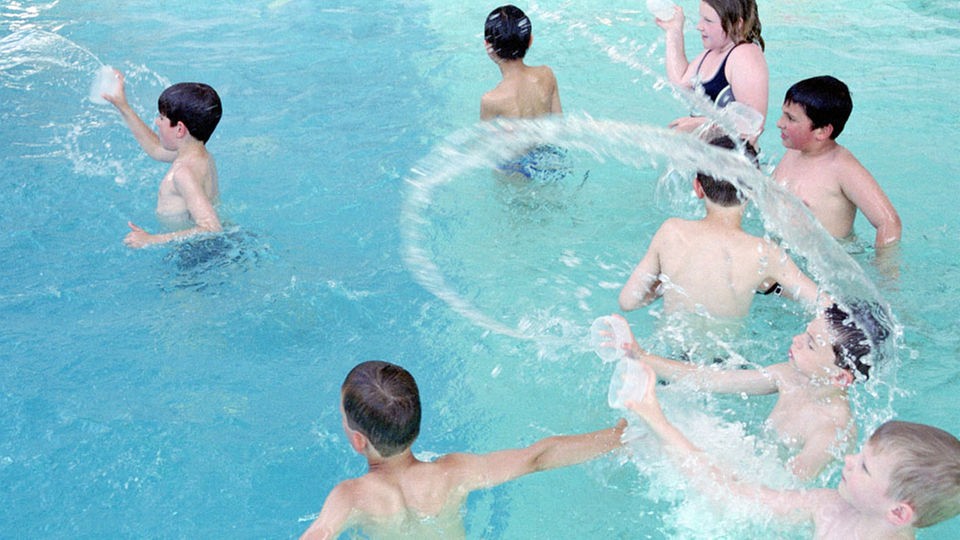 Kinder plantschen in einem Schwimmbad