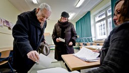 Waehler fuellen am Sonntag (12.02.12) in einem Wahllokal in Duisburg ihre Stimmzettel zur Abstimmung ueber die Abwahl des Oberbuergermeisters von Duisburg, Adolf Sauerland (CDU), in Wahlkabinen aus