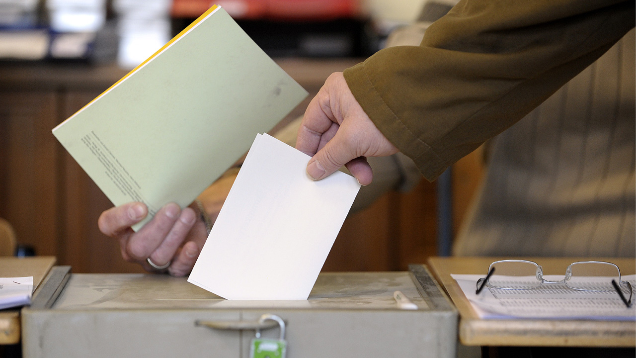 Ein Bürger wirft seinen Wahlzettel in eine Wahlurne