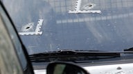 Windschutzscheibe eines Autos mit markierten Einschusslöchern