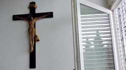Kruzifix neben offenem Fenster