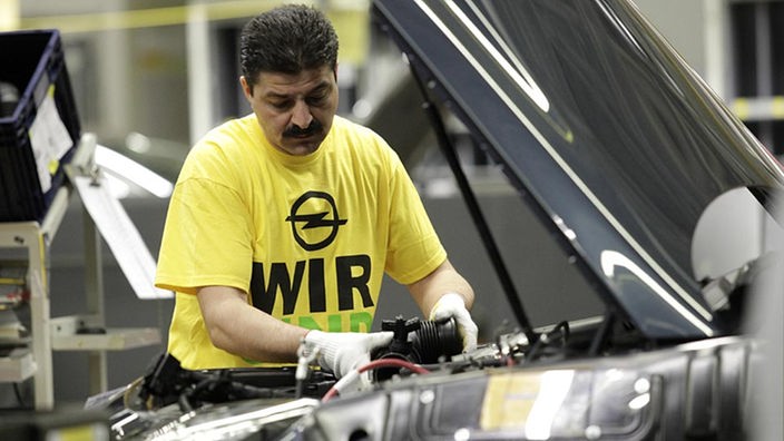 Opel-Mitarbeiter montiert Motorteile