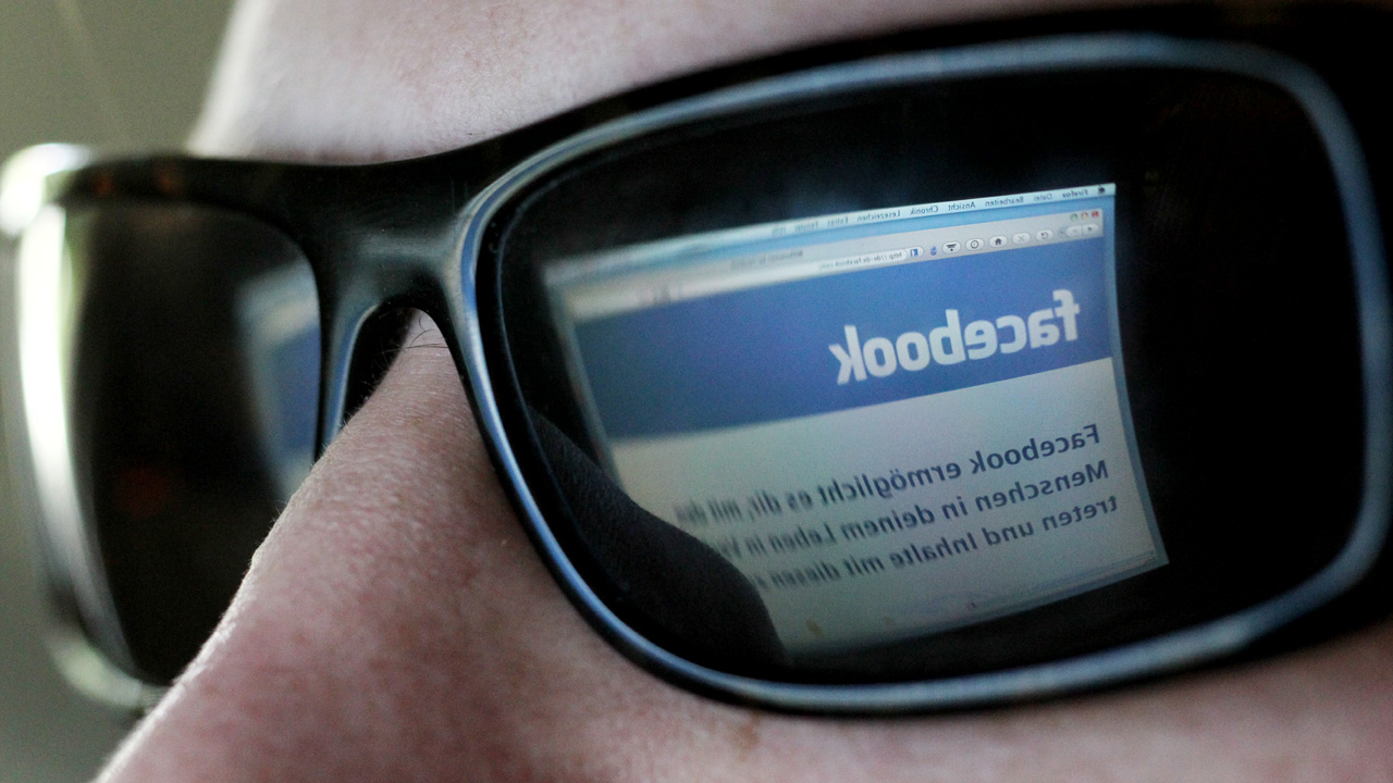 Das Logo des Sozialen Netzwerkes Facebook auf dem Monitor eines Computers spiegelt sich in einer Sonnenbrille