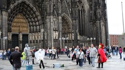 Menschen auf der Kölner Domplatte vor dem Westportal