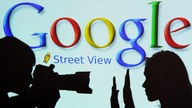 Logo von Google Street View mit dem Schatten eines Fotografen und einer Frau, die nicht fotografiert werden will
