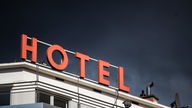 Hoteldach mit Schriftzug "Hotel" vor dunklem Himmel
