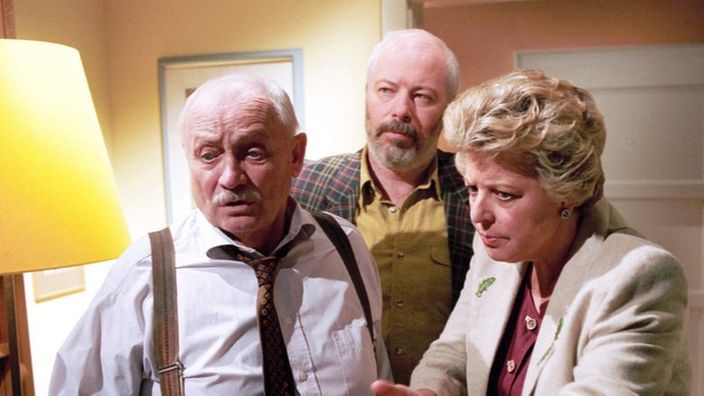 Bei ihrer Rückkehr finden Erich (Bill Mockridge, Mitte) und Helga (Marie-Luise Marjan) den unliebsamen Onkel Franz vor (Martin Rickelt), der sich vor Else versteckt.