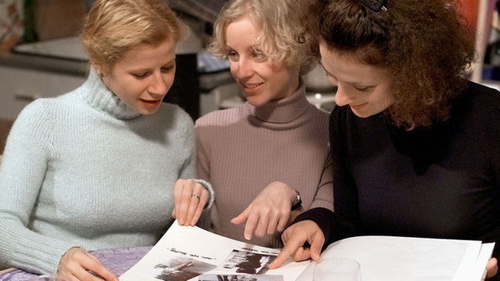 Carmen (Manja Schaar, Mitte), Suzanne (Susanne Evers, rechts) und Nina (Jacqueline Svilarov) betrachten aufgeregt Ninas Hochzeitsbuch.