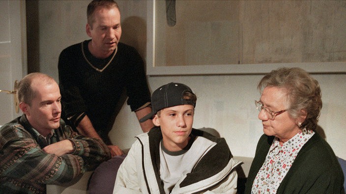 Felix (Marc Oliver Moro, rechts) erfährt von Carsten (Georg Uecker, links), "Käthe" (Claus Vinçon) und Frau Vogt (Dorothea Walda), dass ihn seine Mutter nie wieder sehen will.