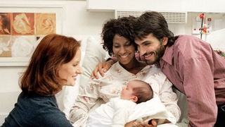 Glückliche Eltern: Mary (Liz Baffoe, Mitte) und Vasily (Hermes Hodolides, rechts) präsentieren Anna (Irene Fischer, links) stolz ihr Baby.