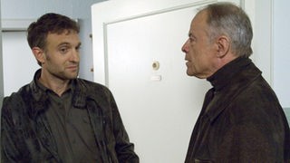 Hajo (Knut Hinz, rechts) stellt Julian (Urs Villiger) wegen der eigenartigen Dreharbeiten in der Zenker-Wohnung zur Rede.