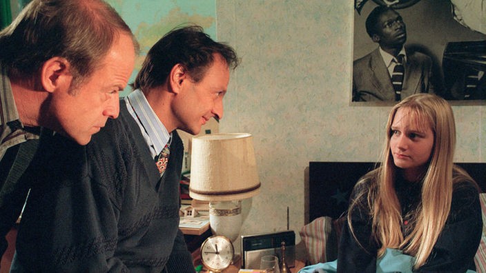 Heimleiter Dr. Franzen (Michael Evers) befragt Lisa (Sontje Peplow) in Hajos (Knut Hinz, links) Zimmer. Doch Lisa gibt sich sehr verschlossen.