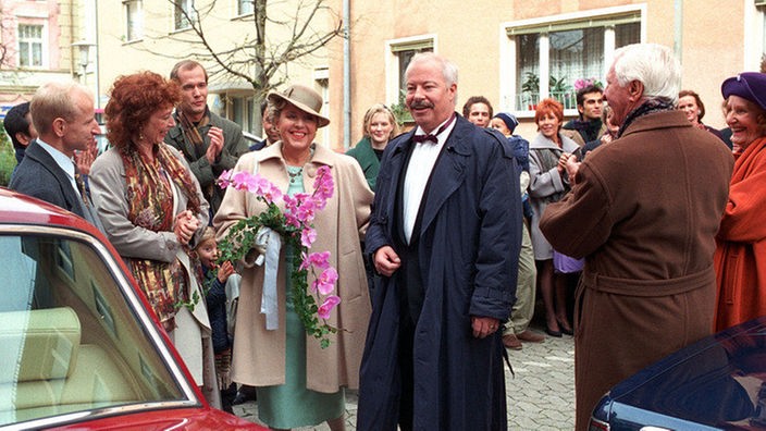 Helga (Marie-Luise Marjan) und Erich (Bill Mockridge, Mitte) lassen sich von den umstehenden Hochzeitsgästen hochleben.