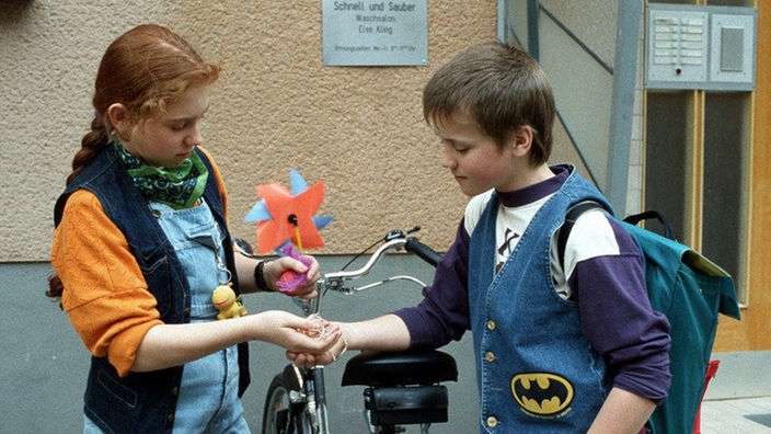 Iffi (Rebecca Siemoneit-Barum) gibt Klaus das Geld für Timos (Moritz A. Sachs) Geburtstagsgeschenk.