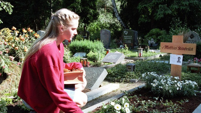 Lisa (Sontje Peplow) legt schuldbewusst Blumen auf Matthias' Grab nieder.