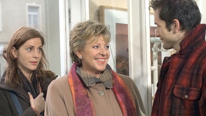 Marion (Ulrike C. Tscharre, links) hat Helga (Marie-Luise Marjan) aus der Klinik abgeholt. Alex (Joris Gratwohl) begrüßt erfreut seine Chefin.