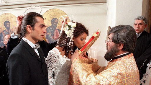 Mary (Liz Baffoe) und Vasily (Hermes Hodolides) werden in einer griechisch-orthodoxen Zeremonie vermählt.
