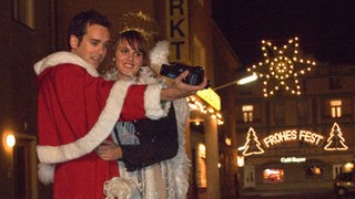 Roberto (Tim Knauer, links) und Jack (Cosima Viola) haben ihren Job als Weihnachtsmann erfolgreich erledigt und probieren nun das Geschenk für Anna und Hans aus.