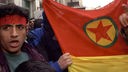 Mann mit Fahne und Stirnband mit der Aufschrift PKK