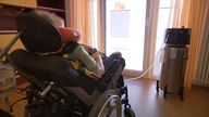 Patientin von hinten in einem Rollstuhl sitzend