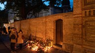 Trauernde haben nach dem Anschlag an der Mauer der Synagoge in Halle Blumen niedergelegt und Kerzen angezündet.