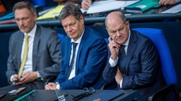 Christian Lindner (FDP), Bundesminister der Finanzen, (l-r) sitzt neben Robert Habeck (Bündnis 90/Die Grünen), Bundesminister für Wirtschaft und Klimaschutz, und Bundeskanzler Olaf Scholz (SPD) auf der Regierungsbank im Bundestag.