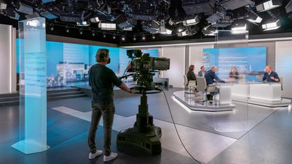 Totale Presseclubstudio mit Kameramann, Gästen und Moderator Volker Herres