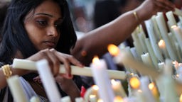 Hinduistische Frau zündet eine Kerze an