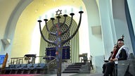 Ein Mitglied der jüdischen Gemeinde Köln hält eine Thorarolle in der Synagoge