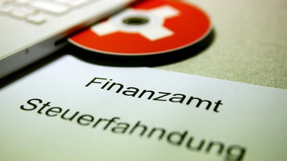 Symbolbild: CD, Zettel mit Aufschrift 'Finanzamt Steuerfahndung'
