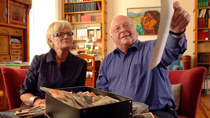 Marita und Norbert Blüm sehen sich in ihrem Wohnzimmer Familienunterlagen an