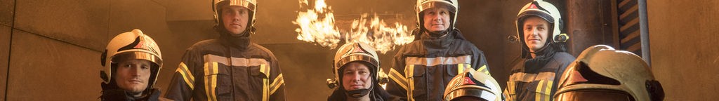 Feuerwehrmänner vor einer brennenden Wand