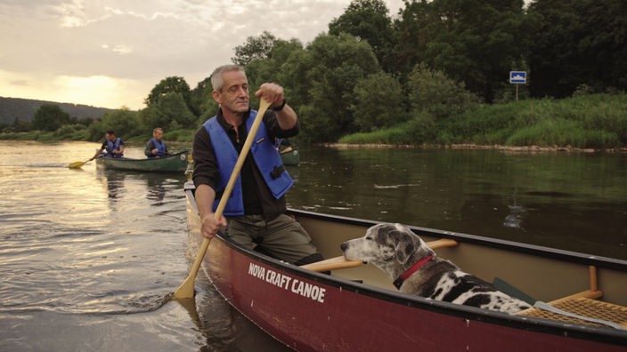 Ein Mann und ein Hund in einem Kanu