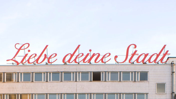 Der Schriftzug "Liebe deine Stadt" auf einem Hausdach