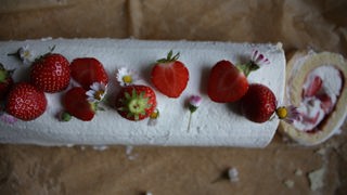 Erdbeer-Biskuitrolle von Theresa Knipschild mit frischen Erdbeerstücken verziert 