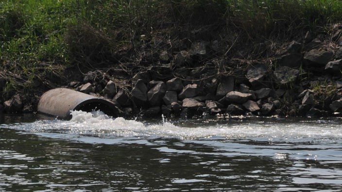 Abwasserrohr leitet Wasser in einen Fluss