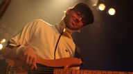Philipp Martin spielt Bass und lächelt mit geschlossen Augen