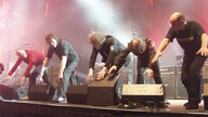 Die Bandmitglieder von Bap beugen sich am vorderen Rand der Bühne herunter und strecken die Arme in Richtung Boden