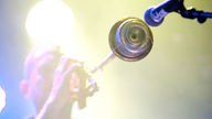 Ein Trompeter der Band "Tu Fawning" steht vor dem Mikrofon