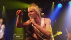 Der Sänger der Band Towers Of London hält sich bei Bootleg im April 2006 das Mikrofon an den Mund und lehnt sich zum Publikum.