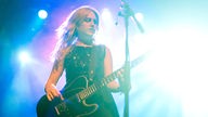 Die zweite Gitarristen der Formation um die Frontfrau Kate Nash steht spielend auf der Bühne.