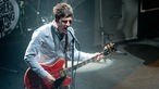 Noel Gallagher am Mikrofon und der Gitarre  auf der Bühne